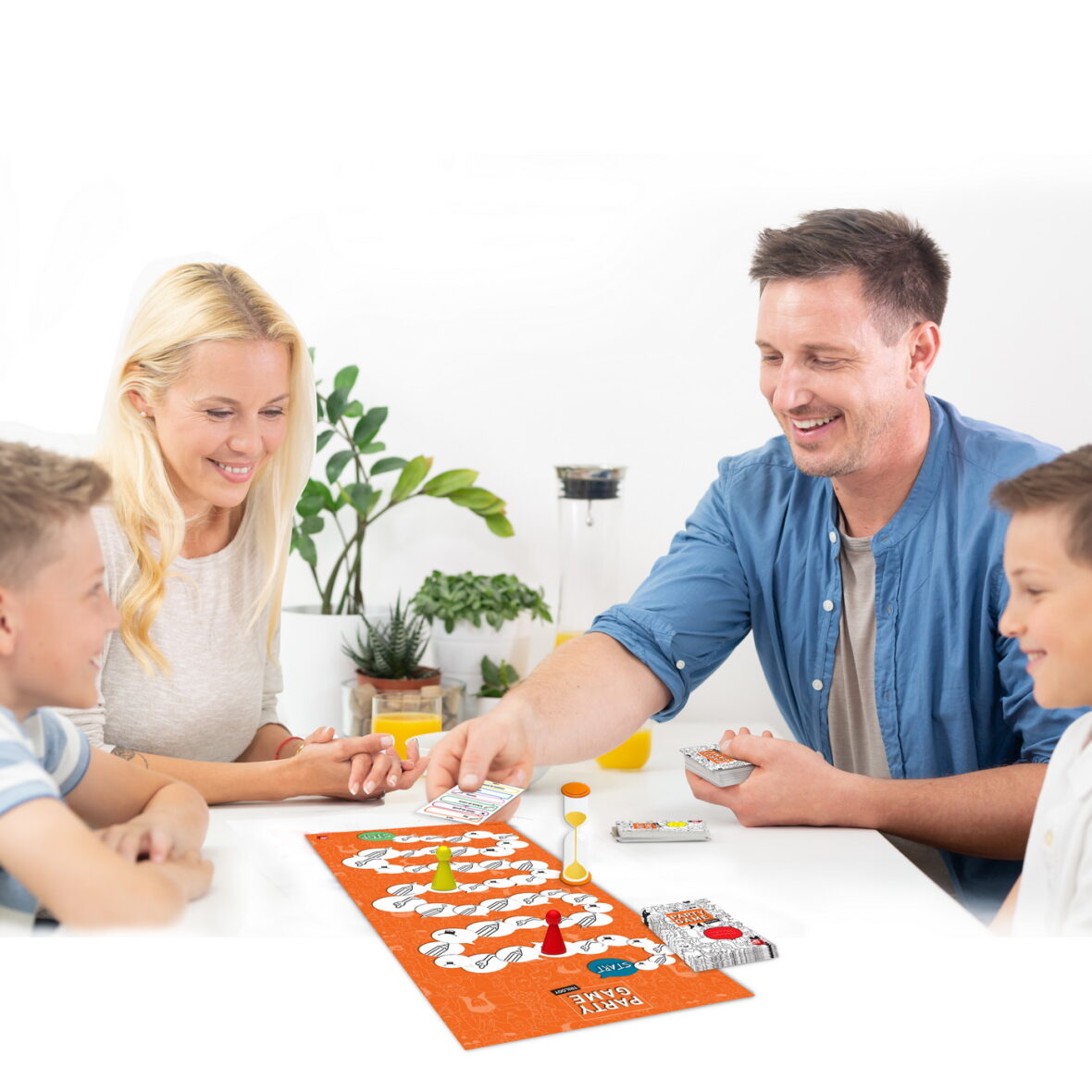 Happy young family playing card game at dining table at bright modern home.