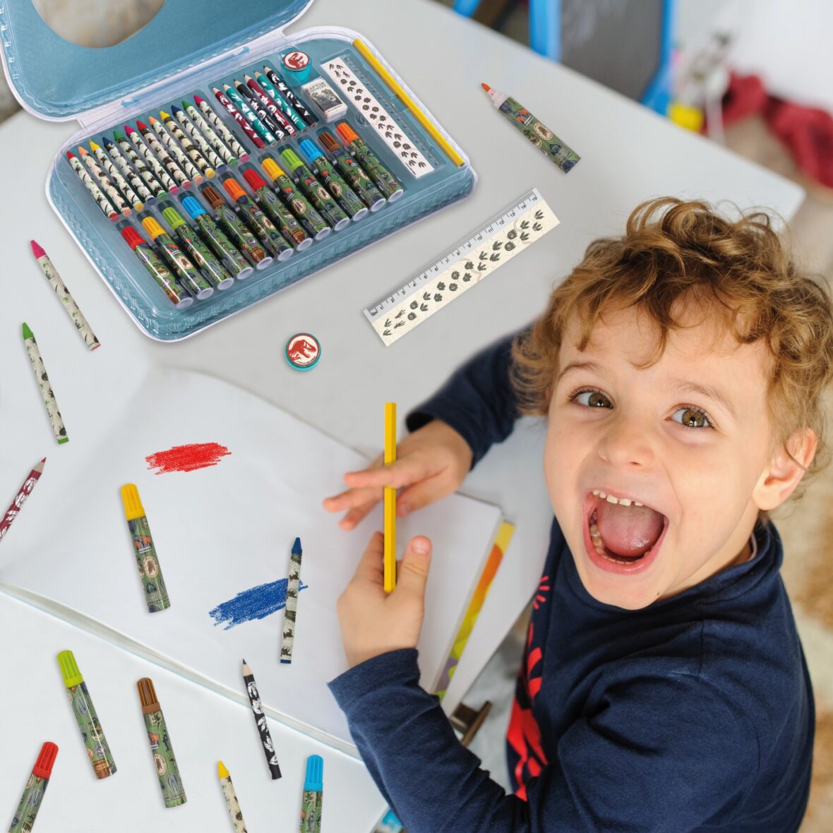 little boy paints greeting card with colour pencils and smile